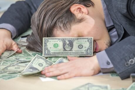 Young businessman working from his office and counting cash money - joy concept