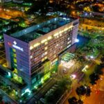 Stunning aerial view of Eka Hospital in Serpong, Indonesia, illuminated at night, capturing vibrant city lights and architecture.