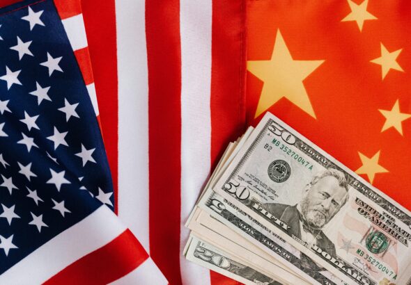 From above of United States banknotes placed on national flags of America and China illustrating international trade concept